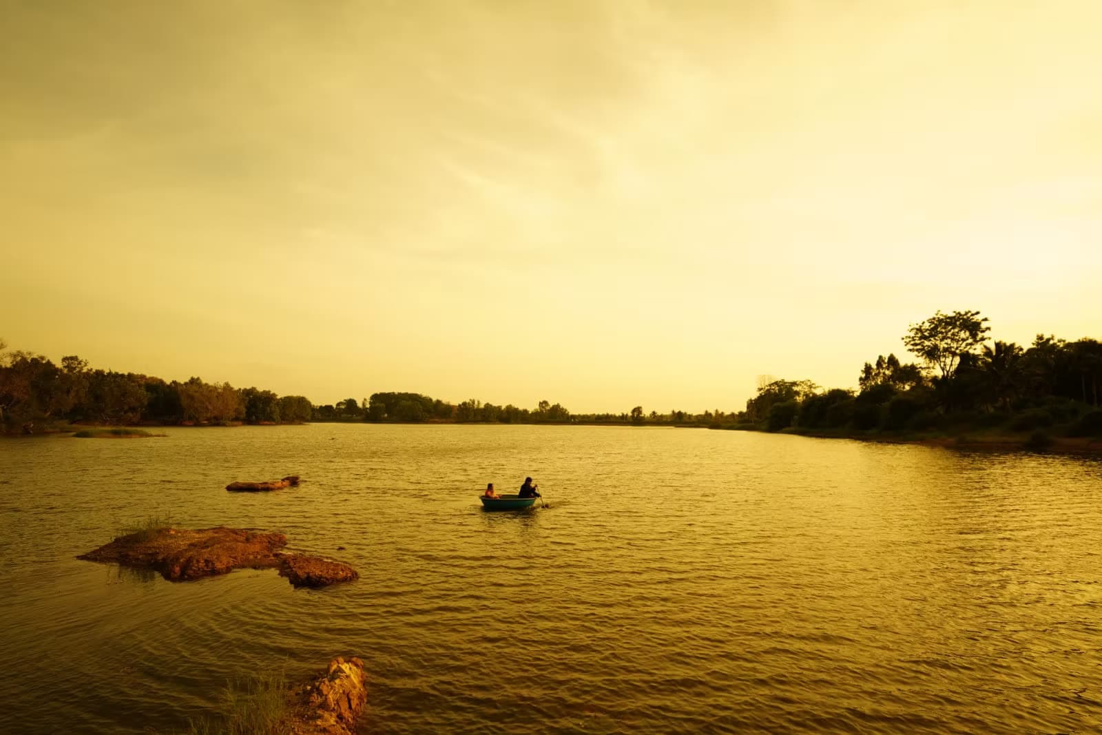 A coracle drifting across the lake under a golden late-evening sky